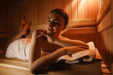 Photo of Beautiful woman lying on bench in sauna