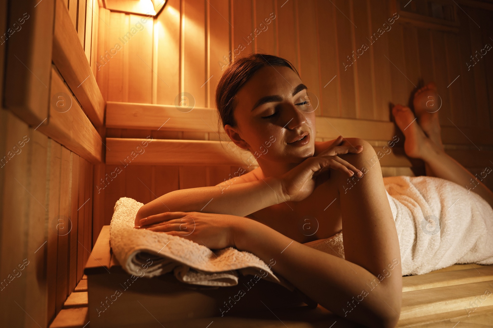 Photo of Beautiful woman lying on bench in sauna