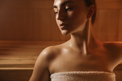 Beautiful woman relaxing in hot sauna, closeup. Space for text