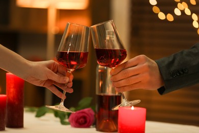 Photo of Couple clinking glasses of wine in restaurant, closeup. Romantic dinner