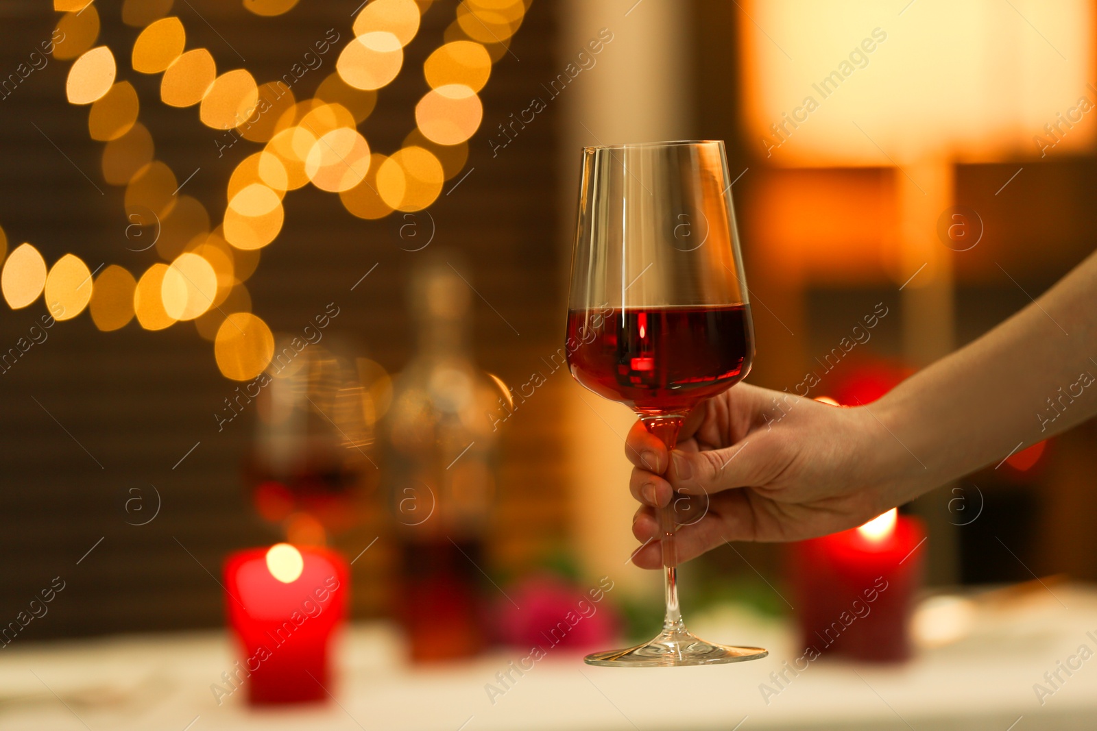 Photo of Romantic dinner. Woman with glass of red wine in restaurant, closeup. Space for text