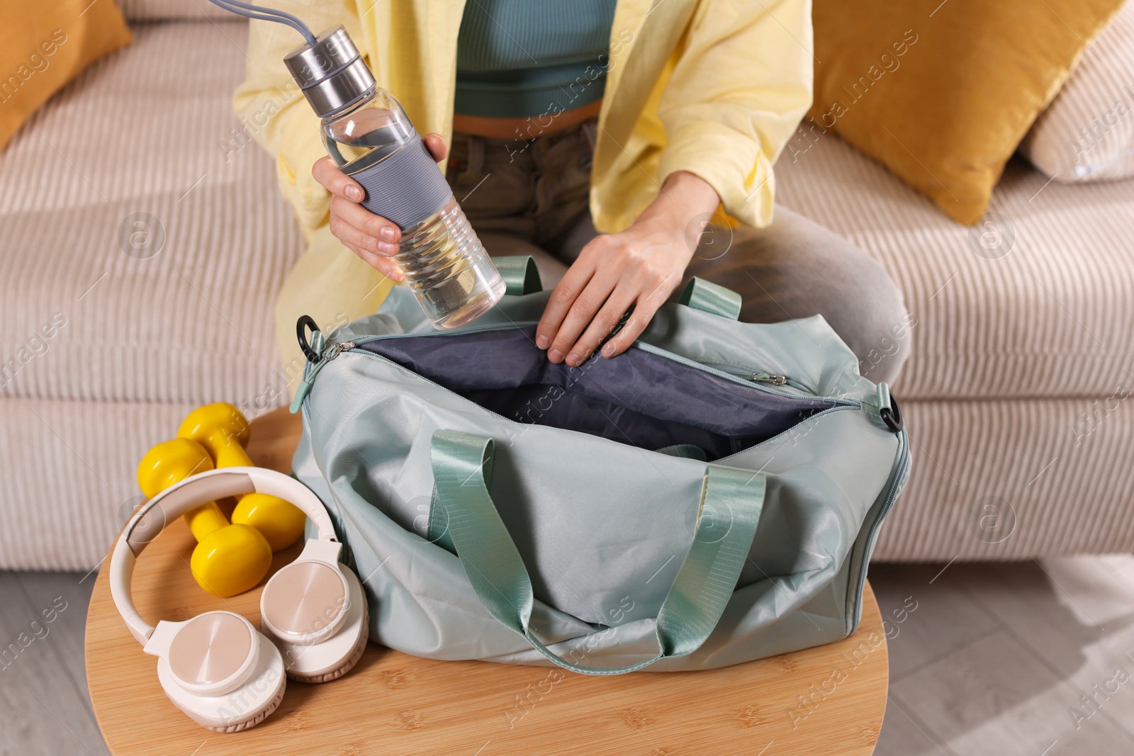 Photo of Woman packing her gym bag at home, closeup