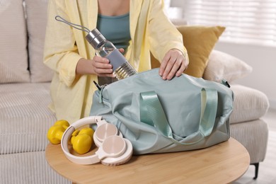 Photo of Woman packing her gym bag at home, closeup