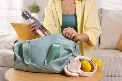 Photo of Woman packing her gym bag at home, closeup