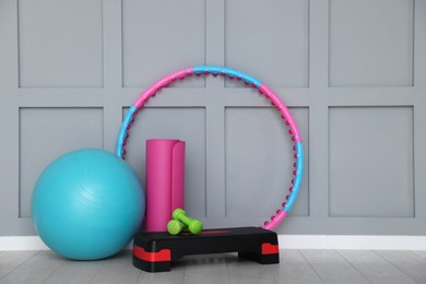 Photo of Different fitness equipment near grey wall indoors