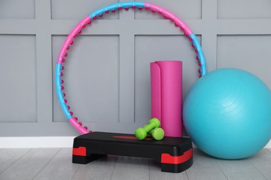 Photo of Different fitness equipment near grey wall indoors