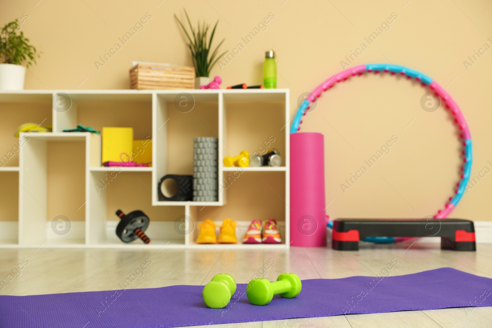 Photo of Different fitness equipment, accessories and sneakers indoors