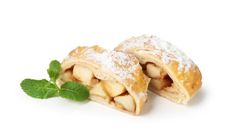 Photo of Pieces of tasty apple strudel with powdered sugar and mint isolated on white