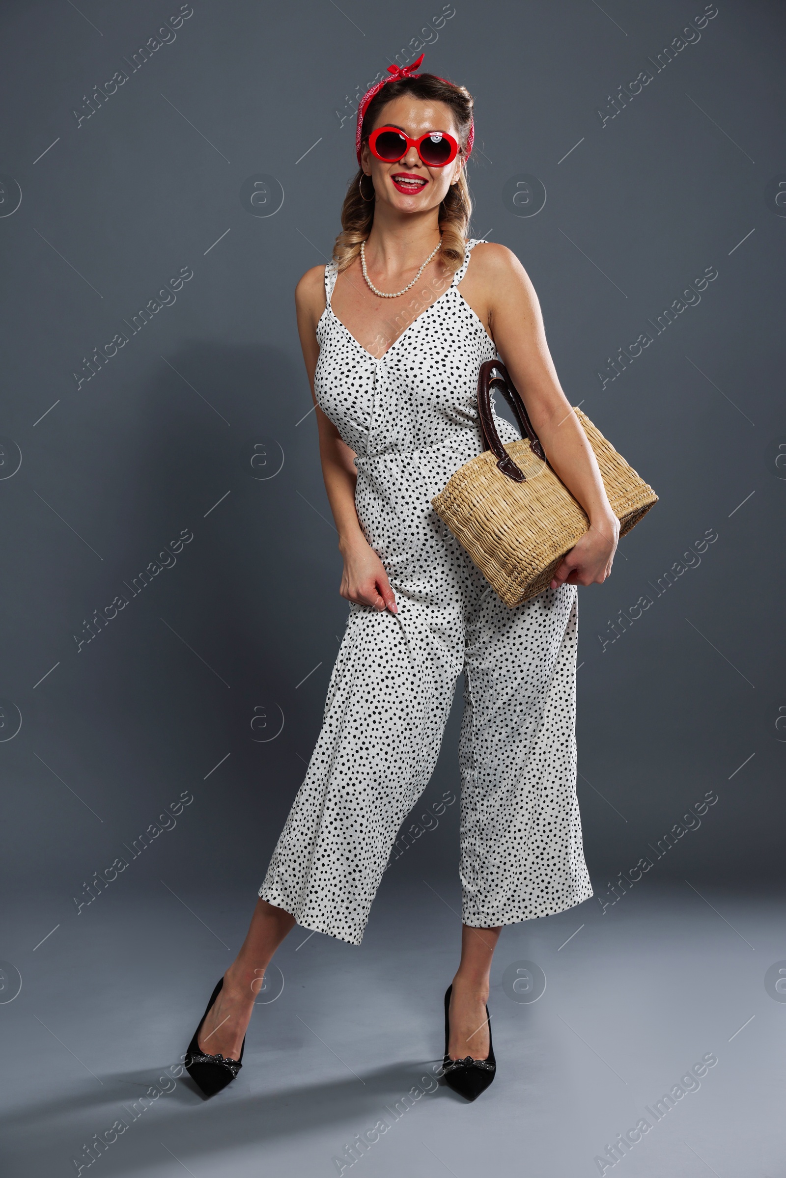 Photo of Happy pin-up woman with bag posing on grey background