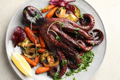 Roasted octopus with vegetables and mushrooms on light grey table, top view