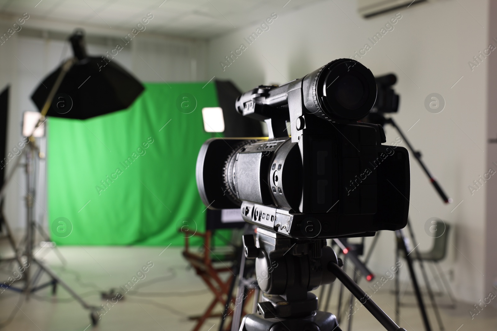 Photo of Modern camera and other professional equipment in film studio, closeup