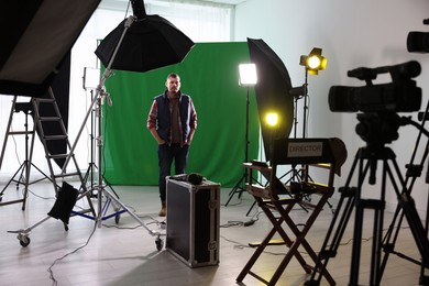 Photo of Man working in modern film studio with professional equipment