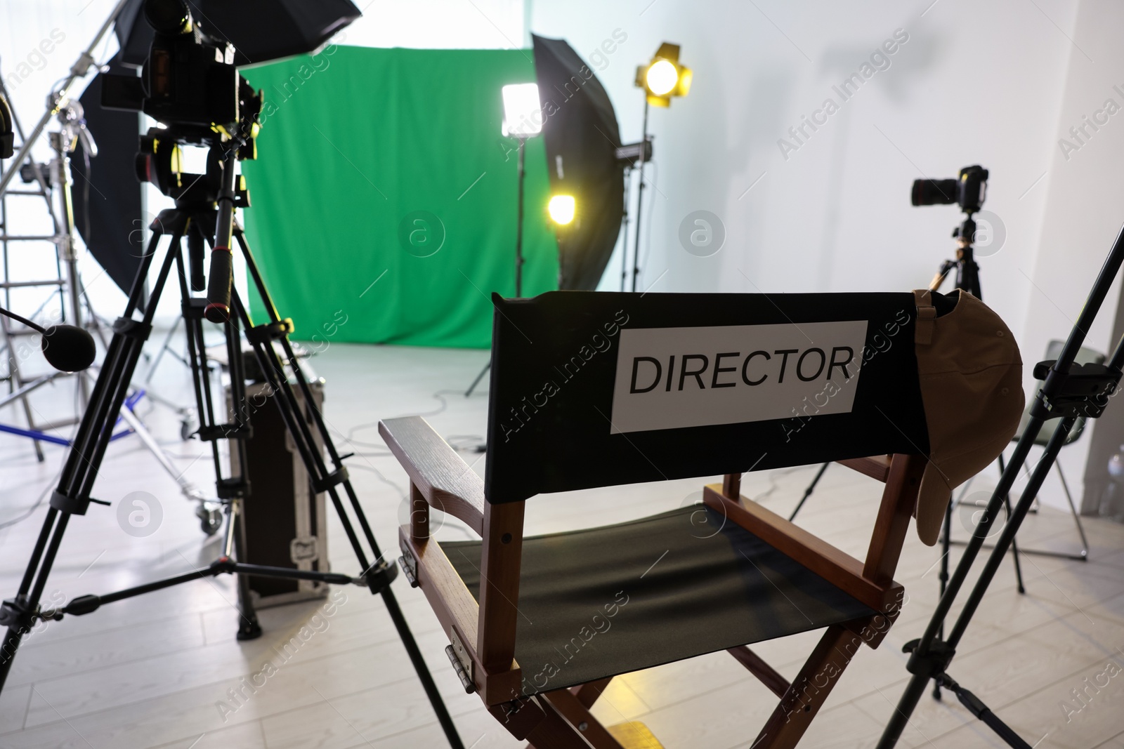 Photo of Chair with word Director and professional equipment in modern film studio