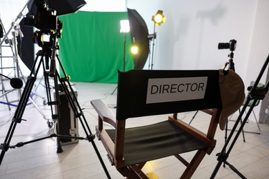 Photo of Chair with word Director and professional equipment in modern film studio