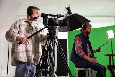 Photo of Men working with professional equipment in modern film studio