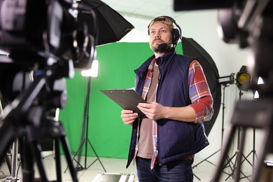 Man with clipboard in modern film studio