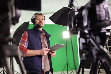 Photo of Man with clipboard in modern film studio