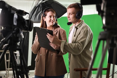 Photo of Man and woman working in modern film studio