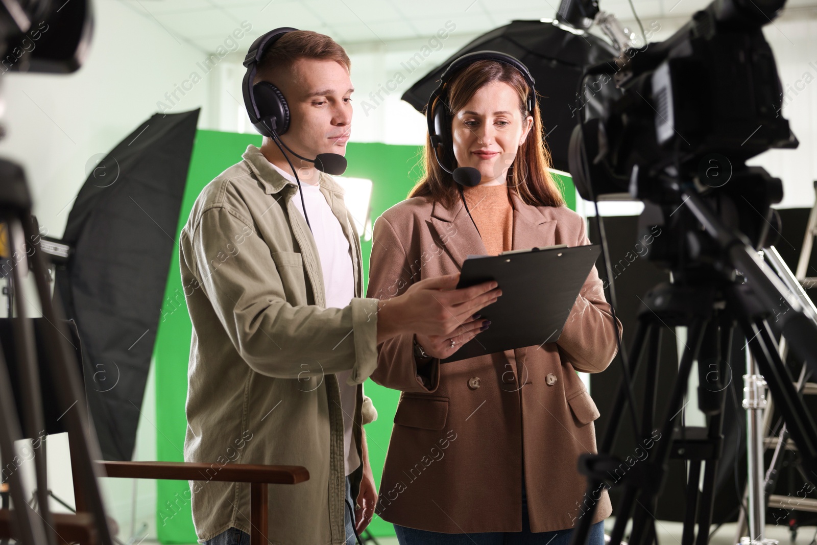 Photo of Man and woman working in modern film studio