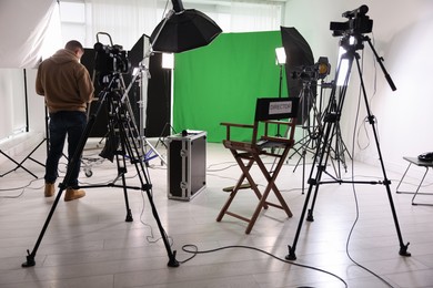 Photo of Man working in modern film studio, back view