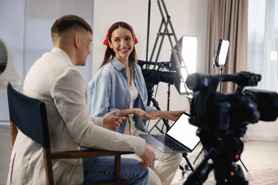 Photo of Man and woman working in modern film studio