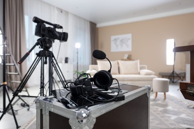 Photo of Headphones, camera and clapperboard in modern film studio, closeup