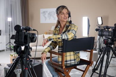 Happy woman with headphones working in film studio