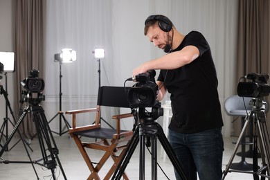 Photo of Cameraman with camera and headphones in film studio