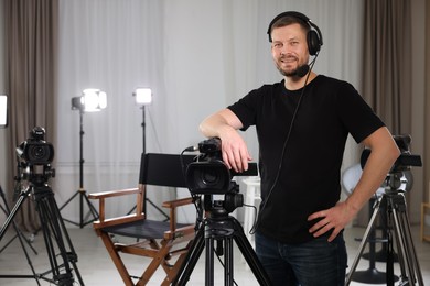 Photo of Cameraman with camera and headphones in film studio