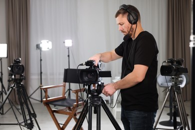 Cameraman with camera and headphones in film studio