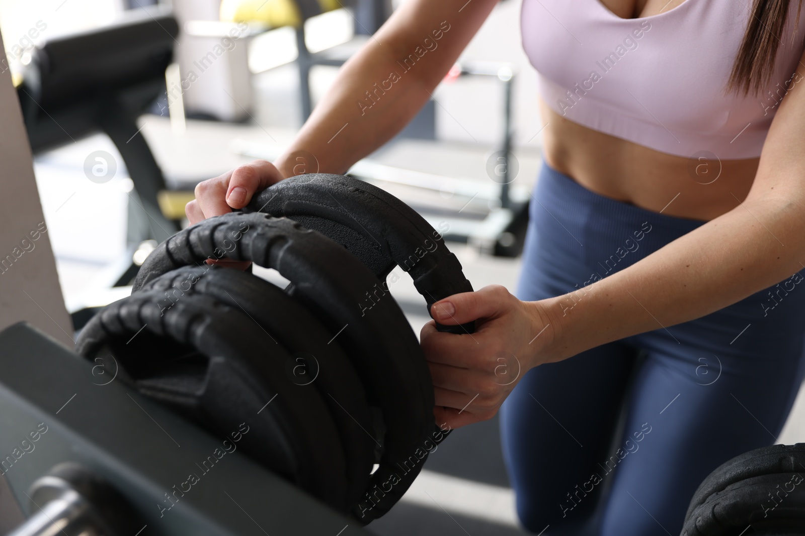 Photo of Woman taking weight plate in gym, closeup