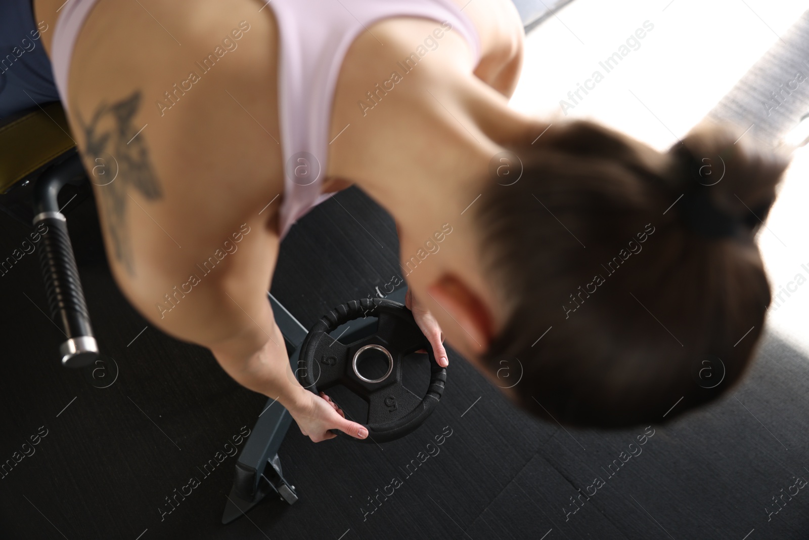 Photo of Woman taking weight plate in gym, above view