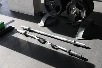 Metal bars and rack with weight plates in gym