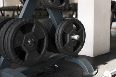 Different weight plates on metal rack in gym