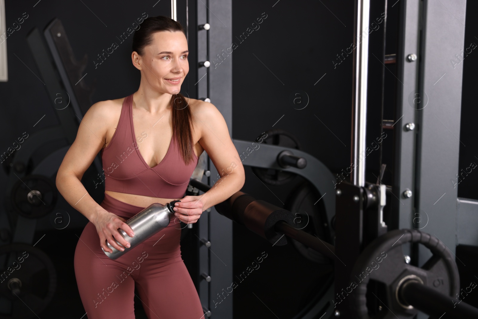 Photo of Smiling woman with thermo bottle in gym. Space for text