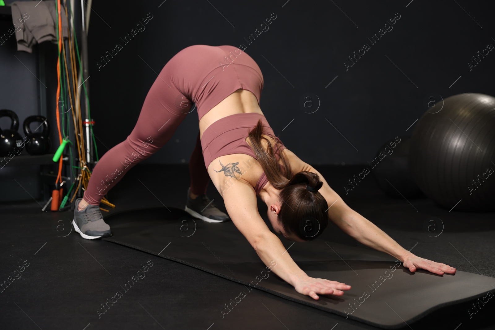 Photo of Athletic woman training on yoga mat in gym