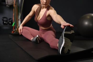 Photo of Woman training on yoga mat in gym, selective focus