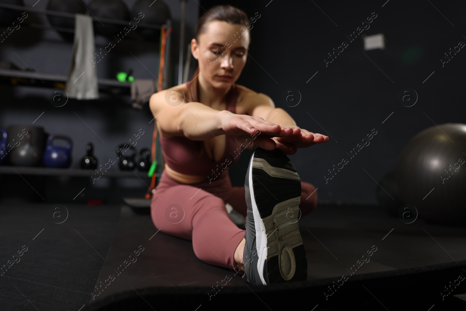 Photo of Athletic woman training on yoga mat in gym