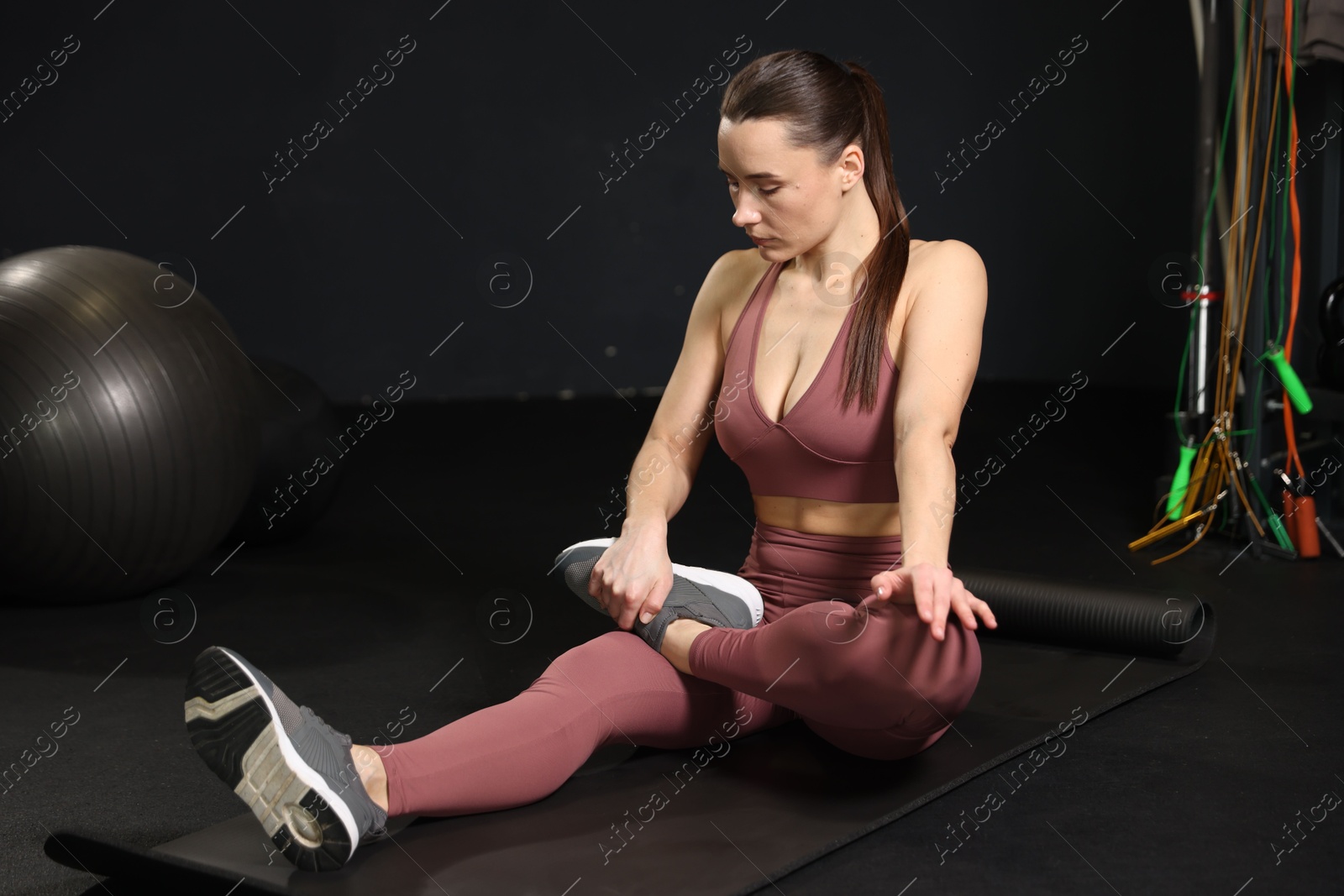 Photo of Athletic woman training on yoga mat in gym