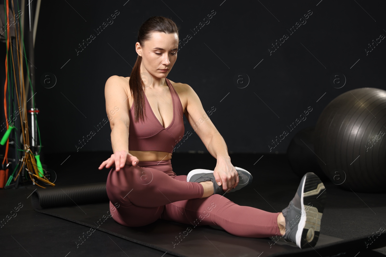 Photo of Athletic woman training on yoga mat in gym