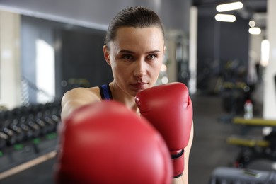 Photo of Athletic woman wearing boxing gloves in gym