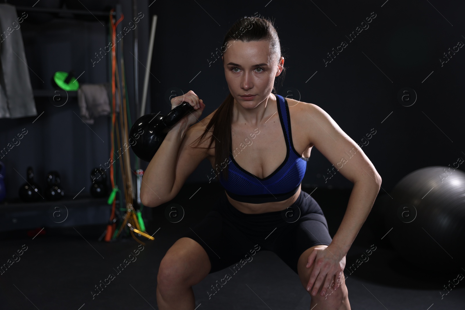 Photo of Athletic woman training with kettlebell in gym