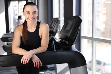 Photo of Portrait of smiling woman on treadmill in gym