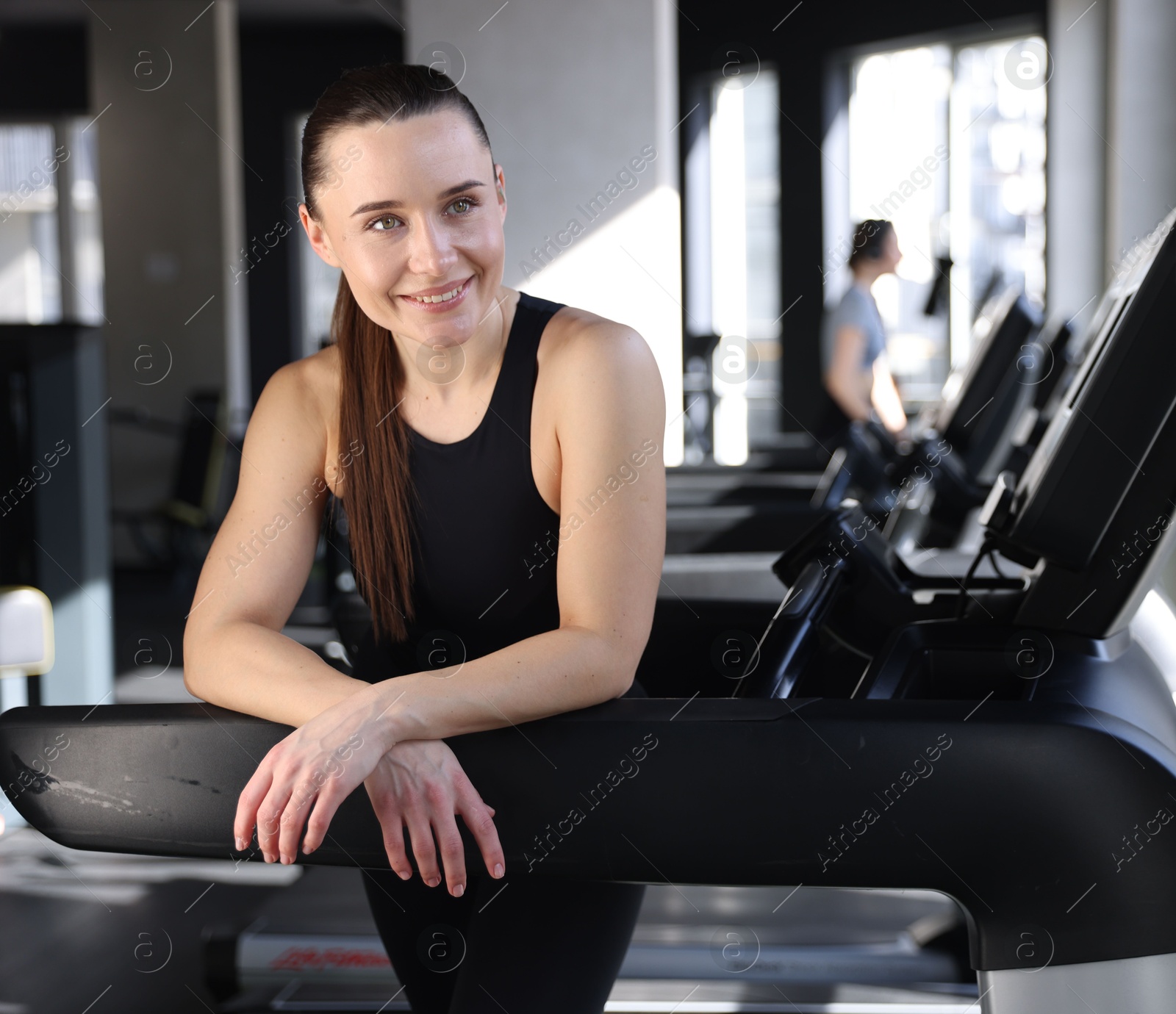 Photo of Portrait of smiling woman on treadmill in gym