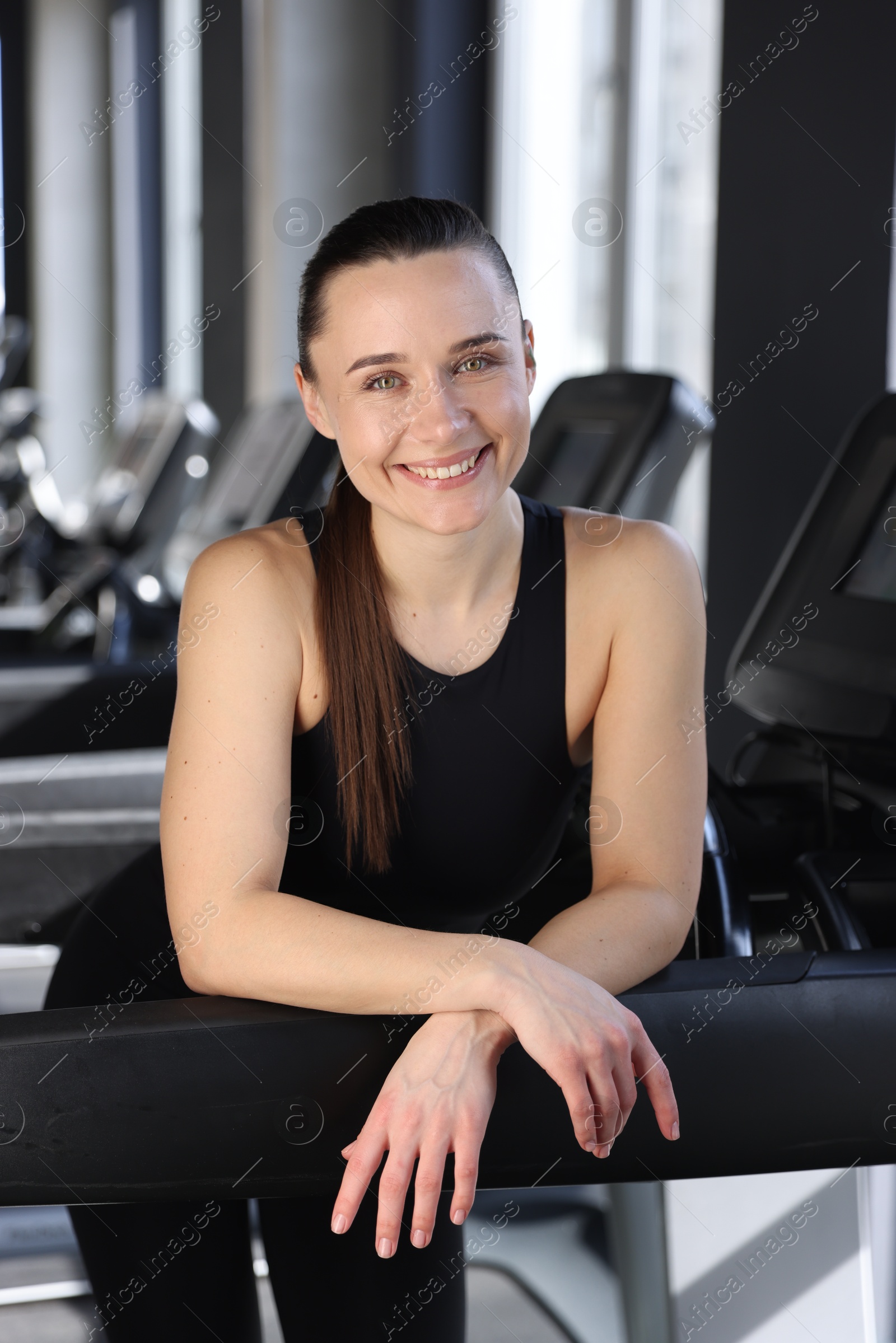 Photo of Portrait of smiling woman on treadmill in gym