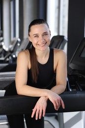 Portrait of smiling woman on treadmill in gym