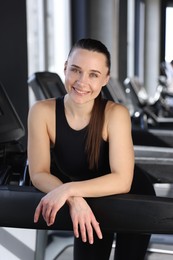 Portrait of smiling woman on treadmill in gym