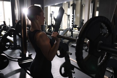 Athletic woman training with barbell in gym