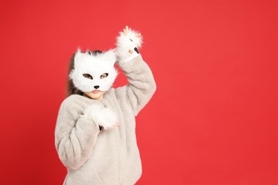 Photo of Quadrobics. Girl wearing cat mask and gloves on red background, space for text