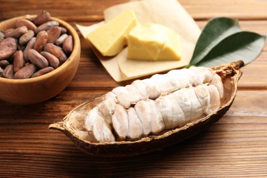 Photo of Cocoa pod with beans and butter on wooden table, closeup